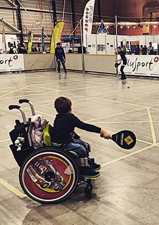 photo of child in wheelchair playing Street Racket